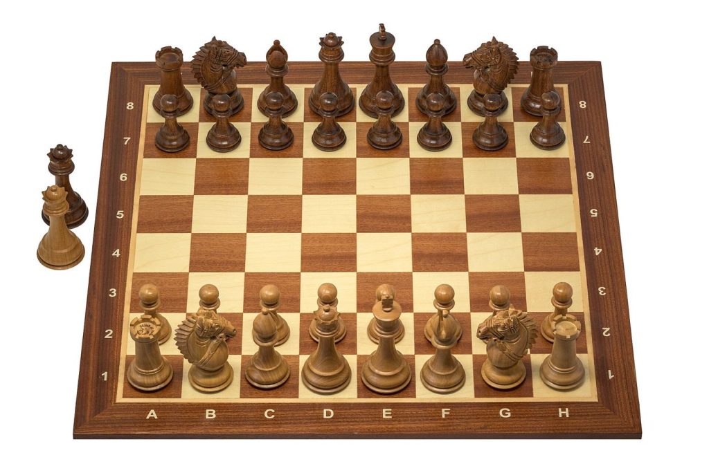 A wooden chess set arranged on a board, ready for the opening moves