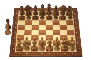 A wooden chess set arranged on a board, ready for the opening moves